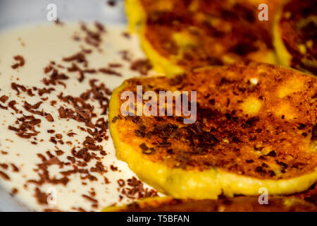 Käsekuchen mit saurer Sahne und Schokolade Chips auf einer Platte. Stockfoto