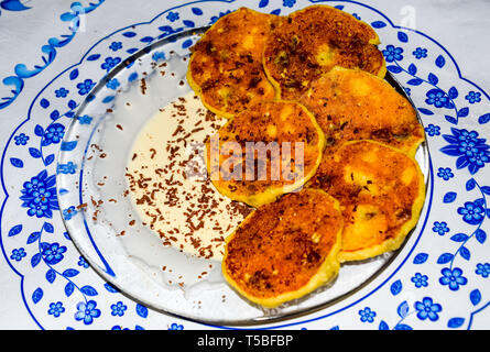 Käsekuchen mit saurer Sahne und Schokolade Chips auf einer Platte. Stockfoto