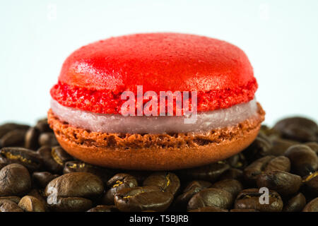 Nahaufnahme von makronen auf einem Stapel von Kaffeebohnen auf weißem Hintergrund Stockfoto