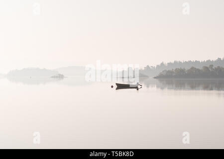 Fischerboot auf Loch Lomond in der Nähe von Alexandria im Morgennebel, Schottland, Großbritannien Stockfoto