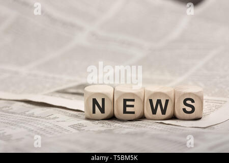 Holzwürfel auf Zeitung zu Wort NACHRICHTEN Stockfoto