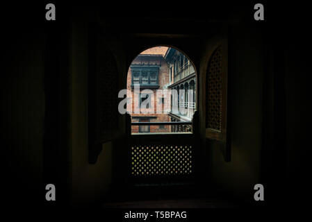 Blick von einem obskuren Zimmer auf den Innenhof der 55 Fenster Palast im historischen Zentrum von Bhaktapur, Nepal entfernt Stockfoto