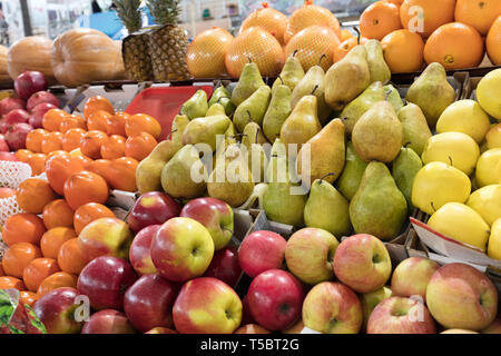 Hellen Hintergrund der frischen Früchte. Orangen, Äpfel, Birnen, Ananas, Granatapfel, Kürbis, persimmonlie liegen in die Fächer, die in der Markt- und gewinnen an Stockfoto