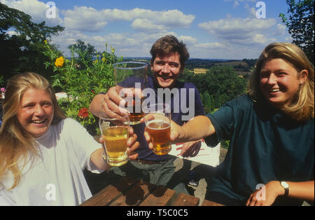 Junge Trinker heben ihre Getränke, um die Kamera auf das Spotted Dog Pub Garten. Penshurst. Kent. England. Großbritannien Stockfoto
