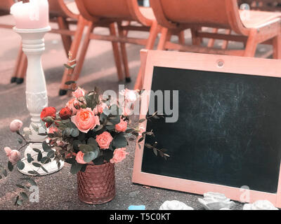Ein Blumenstrauß in einem rustikalen Stil mit einem Rahmen und einem schwarzen Brett für das Zeichnen ein Platz für Text Stockfoto
