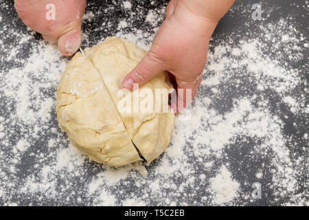 Schneiden ein großes Stück Teig auf einer mit Mehl für die Herstellung von Quark cookies Stockfoto