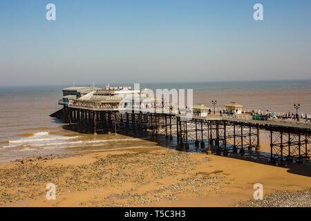 Ein Spaziergang entlang der Promenade an der berühmten Cromer Pier in der Ferne suchen, und den Strand mit keine Menschen. UK Wetter: ein hell und sonnig, aber windig Stockfoto