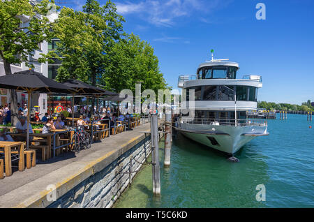 Street Scene mit Restaurant an der Seepromenade mit angedockten Schiff, Friedrichshafen am Bodensee, Baden-Württemberg, Deutschland, Europa. Stockfoto