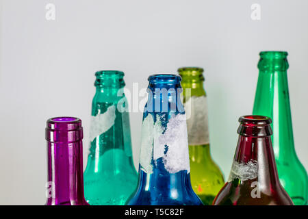 Bild der Engpass der leeren Bier und Wein Glasflaschen auf einem weißen Hintergrund. Grün, Gelb, Pink und Blau. Wiederverwendung, acoholism Stockfoto