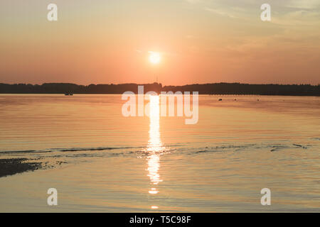 Sonnenuntergang in Chiemsee mit Segelboot navigieren Stockfoto