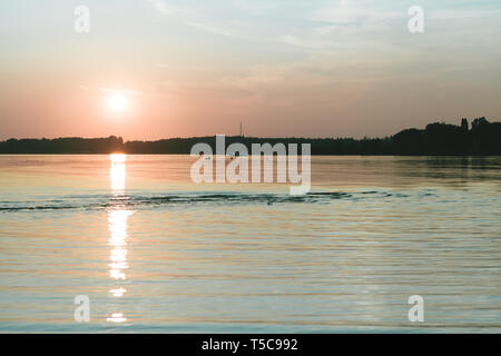 Sonnenuntergang in Chiemsee mit Segelboot navigieren Stockfoto