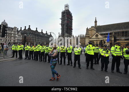 Ein Aussterben Rebellion Demonstrant Spaziergänge Vergangenheit eine Linie von Polizisten in Parliament Square, Westminster, London. Mehr als 1.000 Menschen haben während der Klimawandel Proteste in London verhaftet worden, als die Polizei den Straßensperren verantwortlich für Störungen in der Hauptstadt gelöscht. Stockfoto