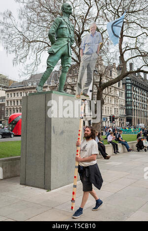 Ein Bild der Veteran Wildlife und ökologischen Broadcaster Sir David Attenborough ist hoch im Parlament Platz neben der Statue von Feldmarschall Jan Christiaan Smuts, der Südafrikanischen und Britischen Commonwealth, Staatsmann, Heerführer und Philosoph, während der einwöchigen Protest vom Klimawandel Aktivisten mit Kampagne der Auslöschung Rebellion Kreuzungen und Brücken rund um die Hauptstadt zu blockieren statt, am 23. April 2019 in London, England. Stockfoto