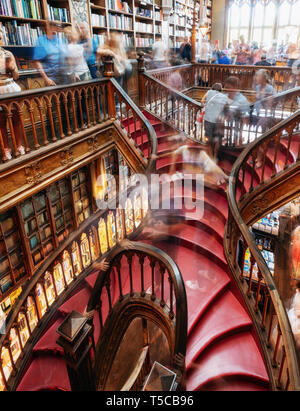 Porto, Portugal - 28. September 2018: Lange Belichtung Bewegung von Menschen auf Bibliothek Lello und Irmao mit großen Wendeltreppe mit roten Schritte, k Stockfoto