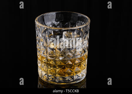 Der Whisky mit Eis in den Felsen Glas auf schwarzem Hintergrund Stockfoto