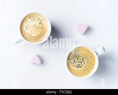 Romantische desk top mit zwei Tassen Kaffee und Rosa herzförmige Marshmallows. Ansicht von oben. Stockfoto