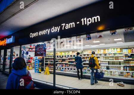 Oxford, Großbritannien - Mar 3, 2017: Frau zu Fuß in der Nähe von örtlichen Sainsbury's Supermarkt im Zentrum von Oxford mit Kunden Stockfoto