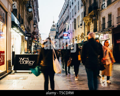 Paris, Frankreich, 19.März 2019: Fußgänger gehen auf der berühmten Fußgängerzone der Rue De Caumartin Straße bei Dämmerung mit Geschäften, Restaurants und dem Printemps Luxus Shopping Mall Stockfoto