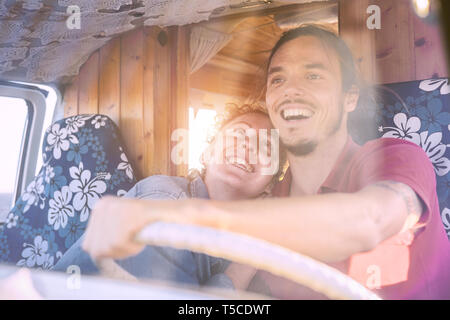 Glücklich lächelnde Paar in einem vintage Minivan - Reisen Leute aufgeregt fahren für eine Fahrt mit einem van Camper Stockfoto