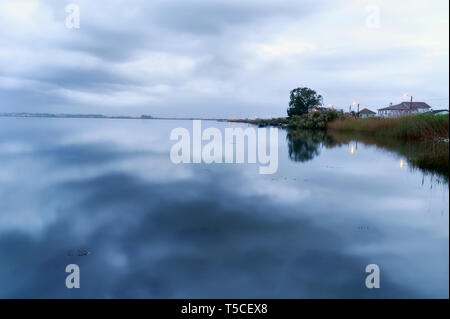 Ufer und bewölkter Himmel, sind in der Oberfläche des Sees ant Blaue Stunde in der Lagune Torreirra, Aveiro, Portugal wider Stockfoto