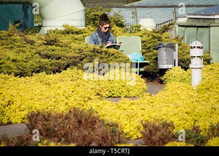 Warschau, Polen. 23 Apr, 2019. Eine Frau liest ein Buch im Garten auf der Dachterrasse der Bibliothek der Warschauer Universität in Warschau, Polen, 23. April 2019. Der Vereinten Nationen für Erziehung, Wissenschaft und Kultur (UNESCO) 23. April als Welttag des Buches im Jahre 1995 benannten Tribut an Bücher und Autoren zu zahlen und die Menschen zu ermutigen, die Freude am Lesen zu entdecken. Credit: Jaap Arriens/Xinhua/Alamy leben Nachrichten Stockfoto