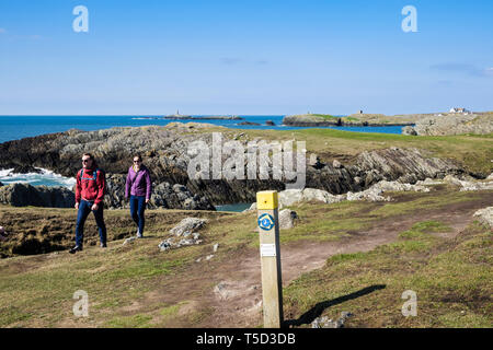 Zwei Menschen zu Fuß auf die Insel Anglesey Coastal Path von Rhoscolyn, Isle of Anglesey, Wales, Großbritannien, Großbritannien Stockfoto