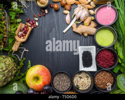 Ausgewogene Ernährung Lebensmittel Samen, Bohnen, Superfoods, Gemüse, microgreens auf dunklen Holztisch, Ansicht von oben. Vegetarische oder Diät Lebensmittel Stockfoto