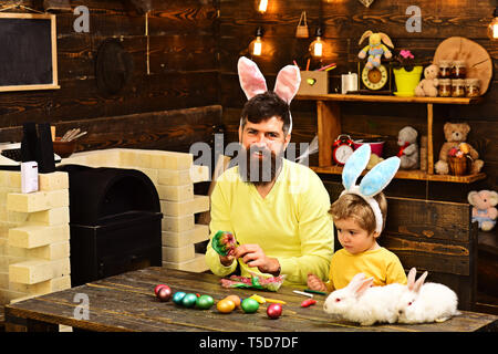 Kind und Vater holding Korb mit bemalten Eiern. Stockfoto