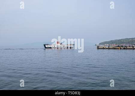 Largs, Schottland, Großbritannien - 20 April, 2019: Largs Pier und der Cal-Mac Fähre auf einem ungewöhnlich warmen Tag für die Osterwoche. Stockfoto