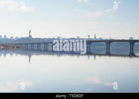 Malerischer Blick auf Mutter Heimat Denkmal über Dnipro River mit Paton Bridge und die Skyline der Stadt Kiew, Ukraine Stockfoto