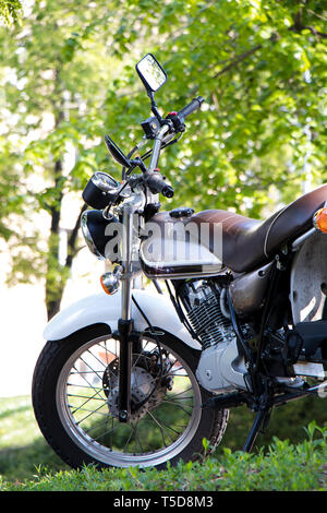 Geparkt vintage elegante Motorrad im Frühling Natur Hintergrund, Low Angle View Stockfoto