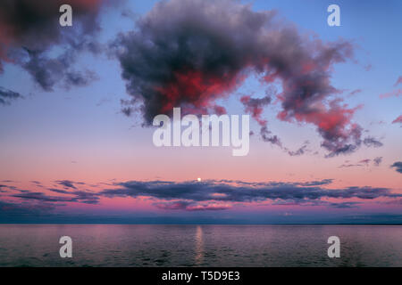 Schönen Sonnenuntergang Wolken über dem Horizont mit Reflexionen Stockfoto