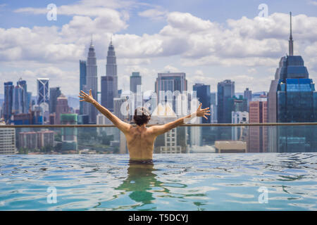 Mann im Schwimmbad in Sunrise entspannen, auf dem Dach in der Stadt. Reiche Leute Stockfoto