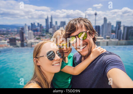 Ferienhäuser und Technologie. Glückliche Familie mit Kind unter selfie zusammen in der Nähe von Pool mit Panoramablick auf die Stadt