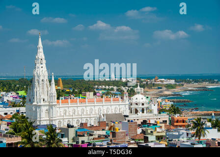 Kanyakumari, Indien - Januar 26,2019: Unsere Liebe Frau von Lösegeld Schrein Kirche hinter bunten Häusern an einem Sandstrand besetzt durch Fischerboote in Kanyakumari Stockfoto