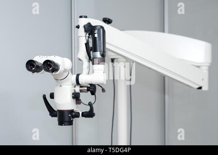 Zahnmedizinische Mikroskop. Die moderne Zahnmedizin im Hintergrund. Medizinische Ausrüstung. Operationsmikroskop mit Rotary doppel Fernglas in weißen Schrank arbeiten Stockfoto