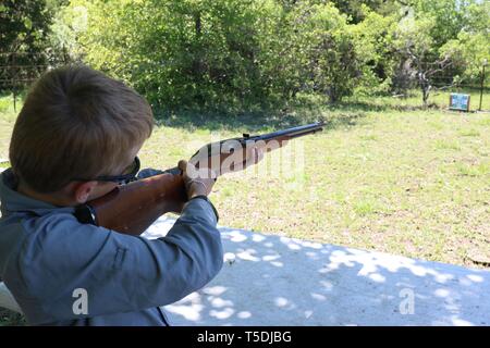 Junge tun Ziel Praxis mit einem Gewehr Stockfoto