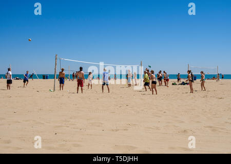 Junge Menschen spielen Volleyball und genießen einen herrlichen, sonnigen Tag an der Oak Street Beach in Chicago Stockfoto
