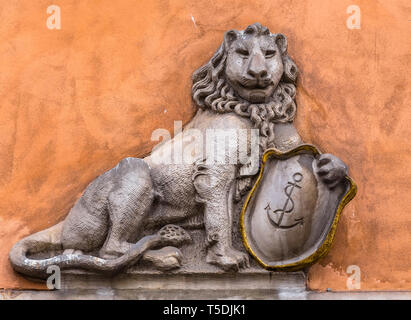 Flachrelief eines Löwen mit einem Schild an der Wand Stockfoto