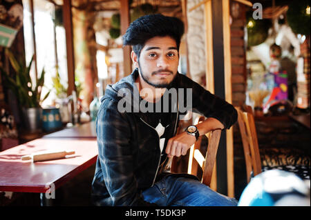 Bart asiatischer Mann in Freizeitkleidung sitzt Innen- Cafe. Stockfoto