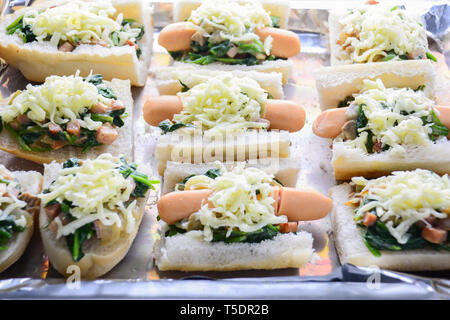 Spinat überbacken mit Käse, Wurst auf Baguette, Französisches Brot Stockfoto
