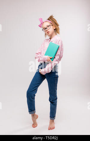 Junges Mädchen mit Brille, junges Mädchen mit Buch auf weißem Hintergrund, lächelnde Mädchen halten Bücher. Schule Mädchen mit viel Bücher für die Hausaufgaben zu lesen, Kind wit Stockfoto