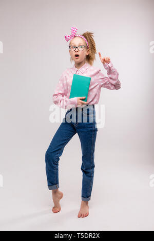 Junges Mädchen mit Brille, junges Mädchen mit Buch auf weißem Hintergrund, lächelnde Mädchen halten Bücher. Schule Mädchen mit viel Bücher für die Hausaufgaben zu lesen, Kind wit Stockfoto