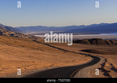 Eine Autobahn Kurven durch eine weite, karge Wüstenlandschaft Stockfoto