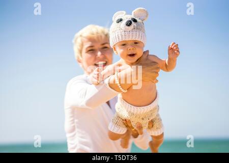 Gerne blonde Mutter mit 4 Monate alten Baby auf den Strand, Portugal Stockfoto