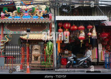 Außerhalb der taoistischen Tempel Wat Mangkon Kamalawat (links), Chinatown, Bangkok, Thailand, mit chinesischen Laternen vor einem Geschäft (rechts) Stockfoto