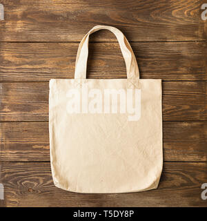 Tasche mit Griffen aus natürlicher Baumwolle für Shopping Produkte Holz- Hintergrund. Ökologie Konzept. Minimalismus. Stockfoto