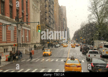 Fahren an einem regnerischen Tag am Central Park West Street in Manhattan, New York City, USA. Ethische Kultur Fieldston Schule auf der linken Seite, Central Park auf der rechten Seite. Stockfoto