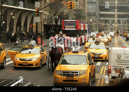 New York, USA. Verkehr in Manhattan, mit einer Pferdekutsche zwischen Taxis. Columbus Circle von der W 59th Street aus gesehen. Stockfoto