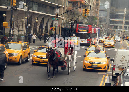 Verkehr in Manhattan, New York, mit einer Pferdekutsche zwischen Kabinen. Columbus Circle aus der W 59th Street gesehen. Stockfoto